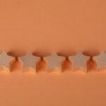 Five wooden star-shaped blocks arranged on an orange surface, perfect for rating concepts.