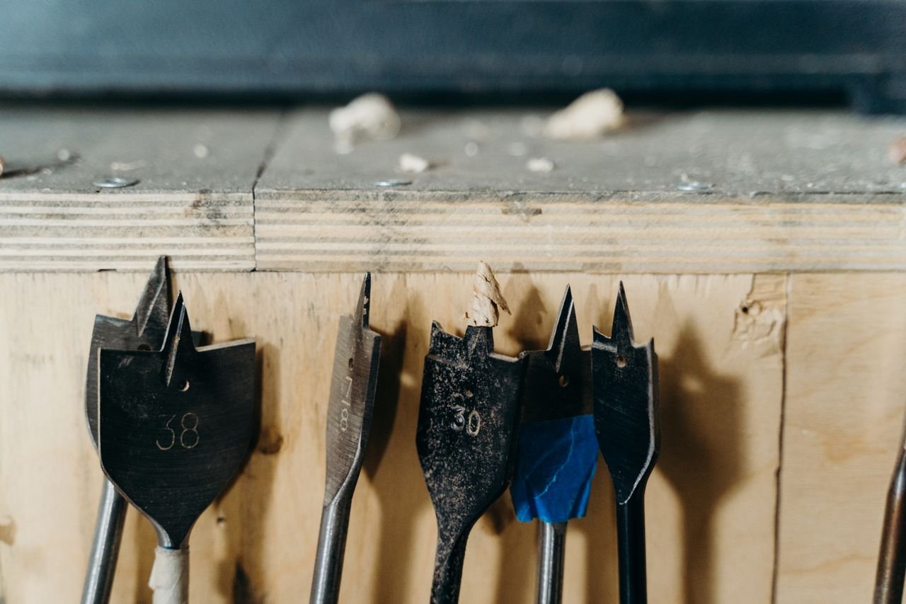 pexels photo 7479034 7479034 Detailed view of woodworking drill bits on a wooden surface in a workshop environment.